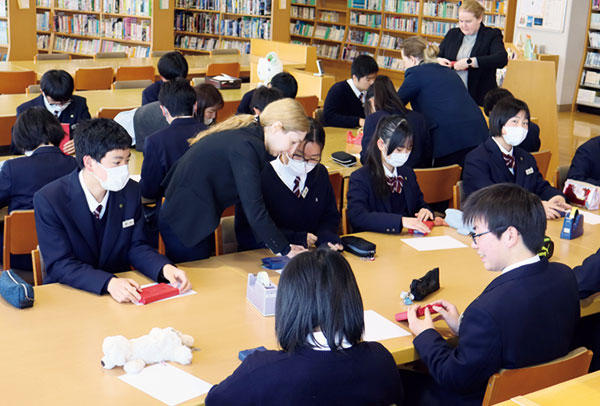 図書館でALTの先生とともに学習する生徒たち