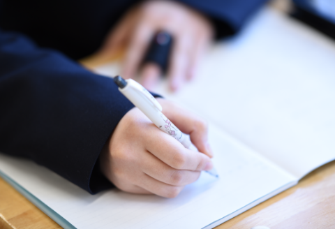 ノートにメモを取っている生徒